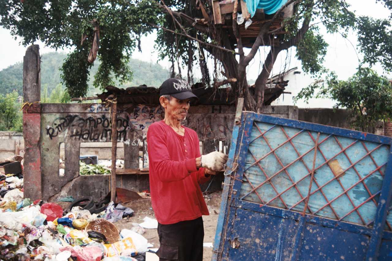Man wearing red shirt near a metal door